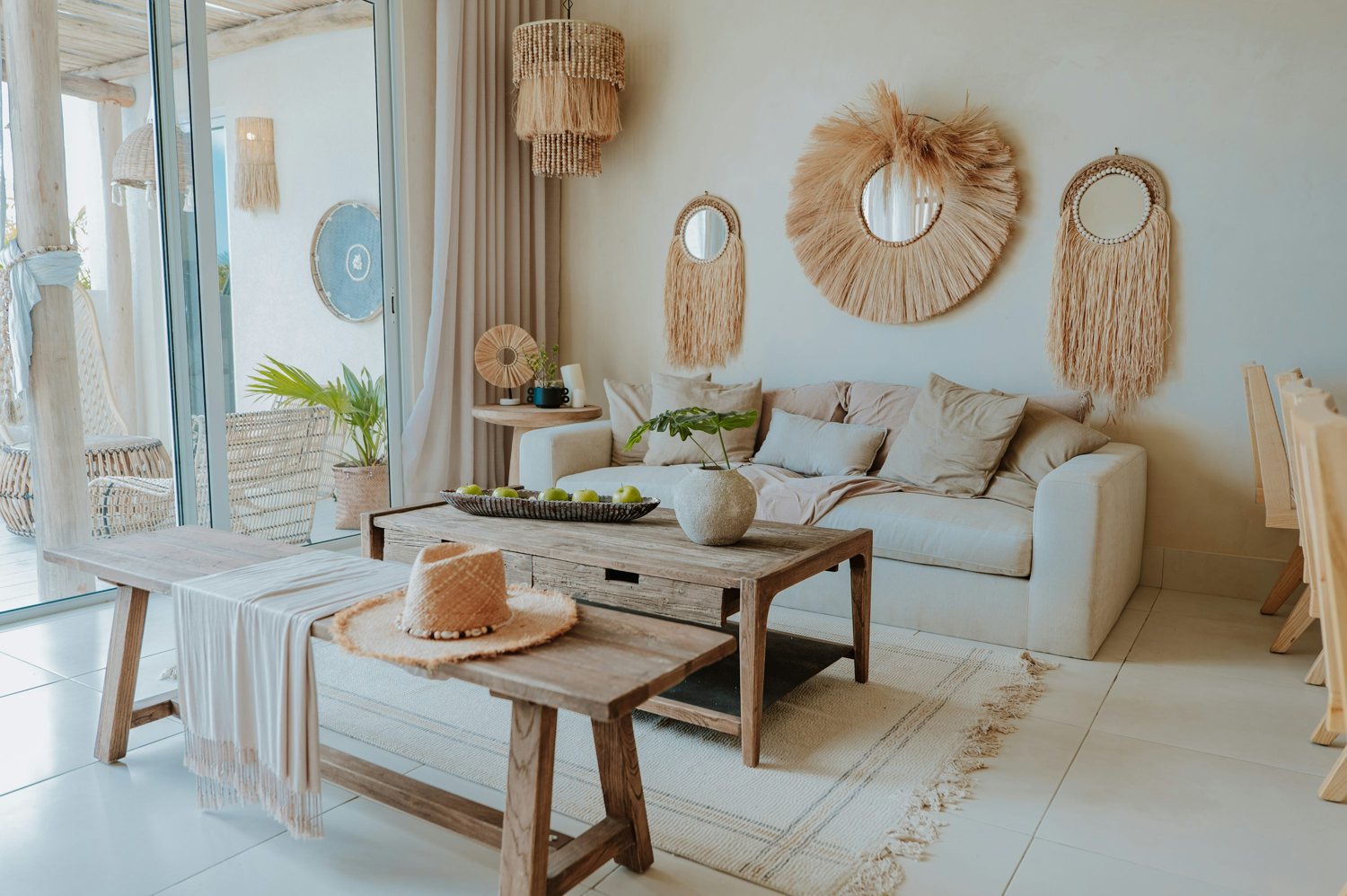 A light-filled living room with a cream sofa, wooden furniture and plants
